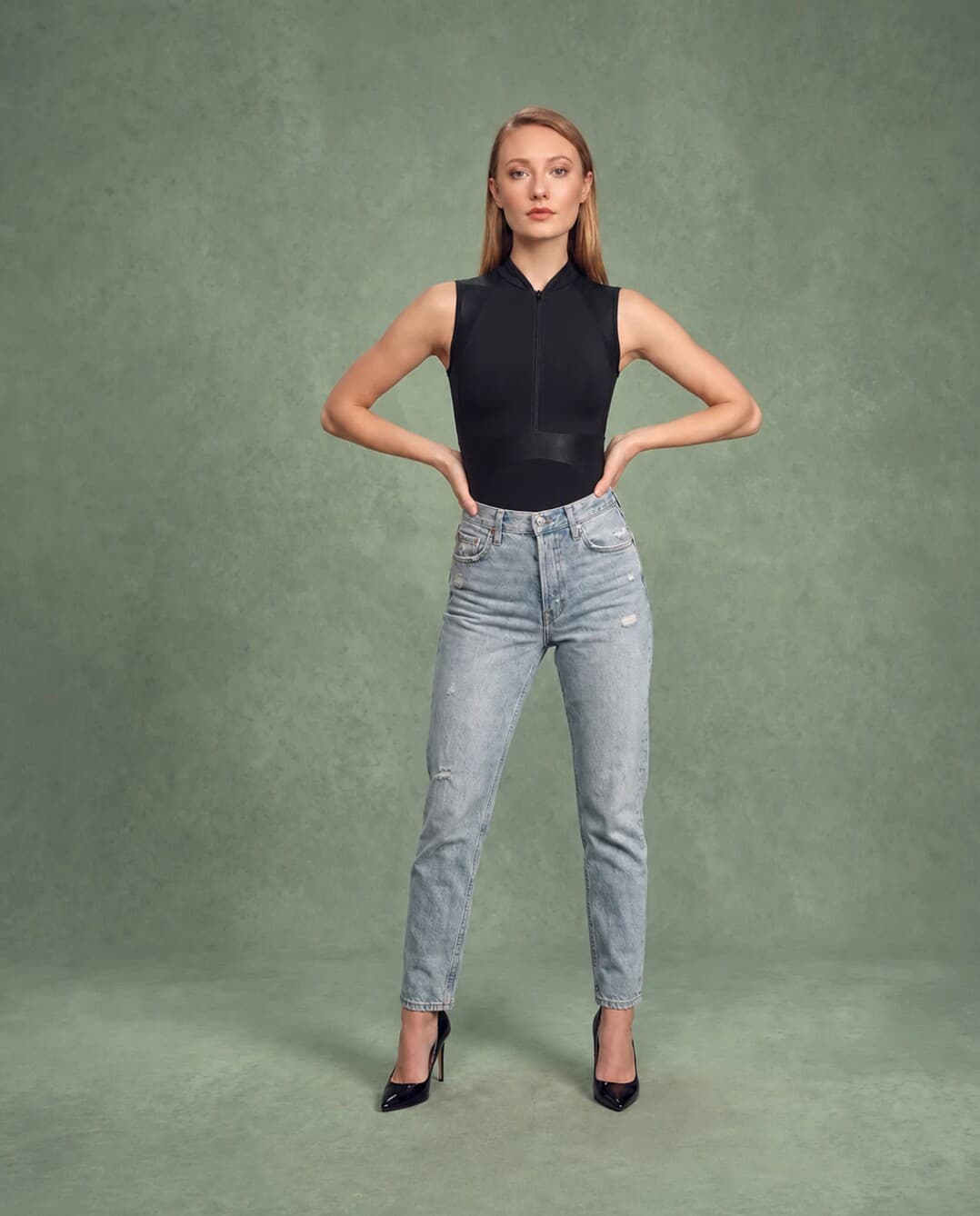 Woman wearing a black leotard and jeans